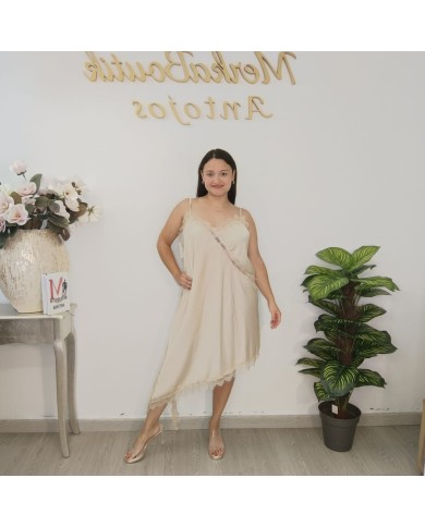 Modelo con vestido SEDUCCIÓN MINI, que estiliza las piernas y aporta un aire moderno al diseño clásico en color beige