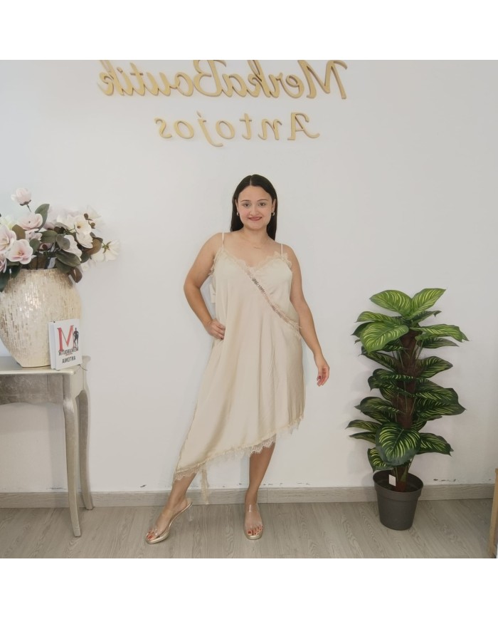 Modelo con vestido SEDUCCIÓN MINI, que estiliza las piernas y aporta un aire moderno al diseño clásico en color beige