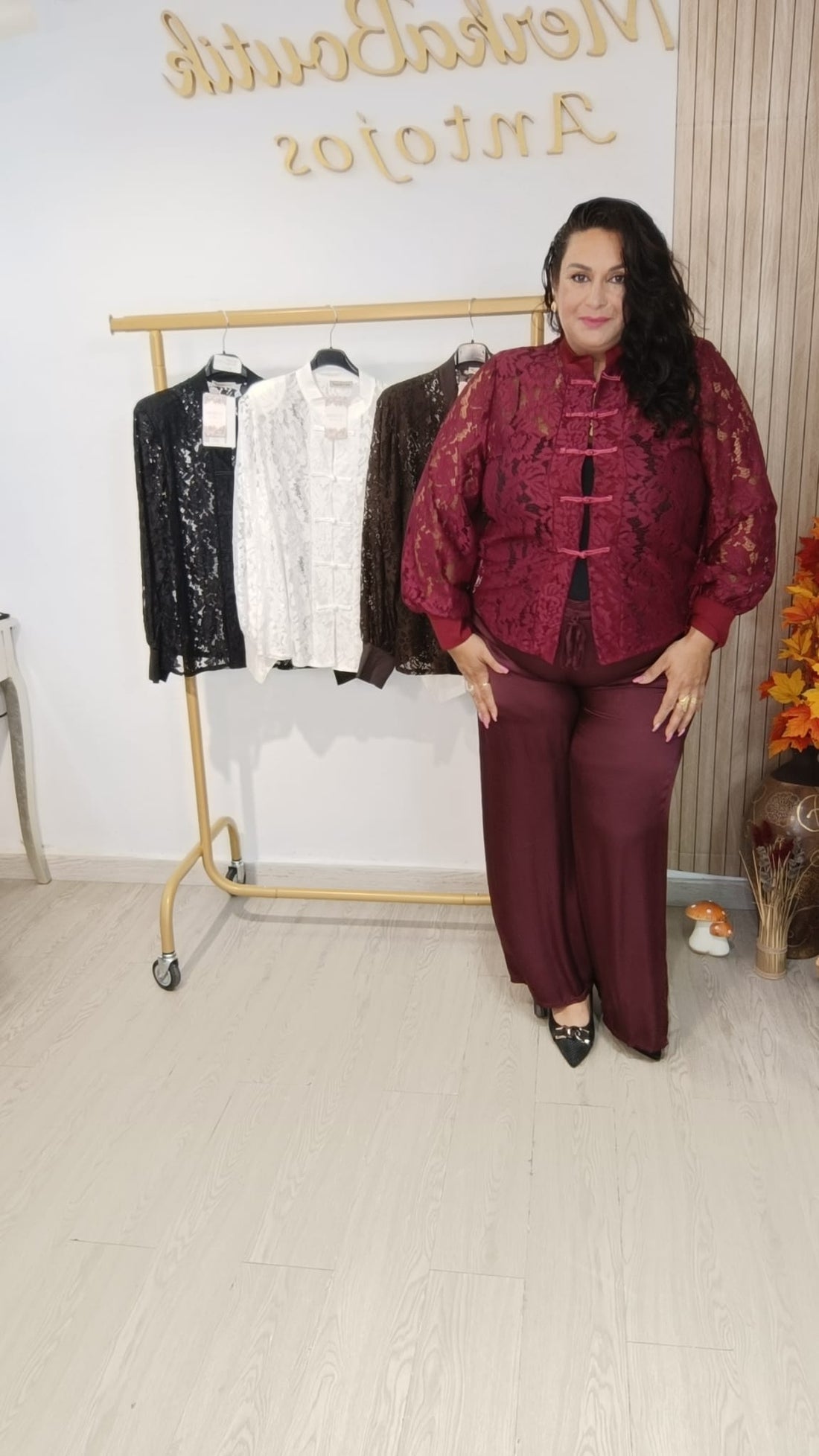 Modelo curvy con Blusa Encaje Mulán burdeos junto a perchero