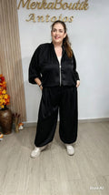 Modelo con Conjunto Bombacho Satinado Mini negro, chaqueta bomber con cremallera y pantalón amplio